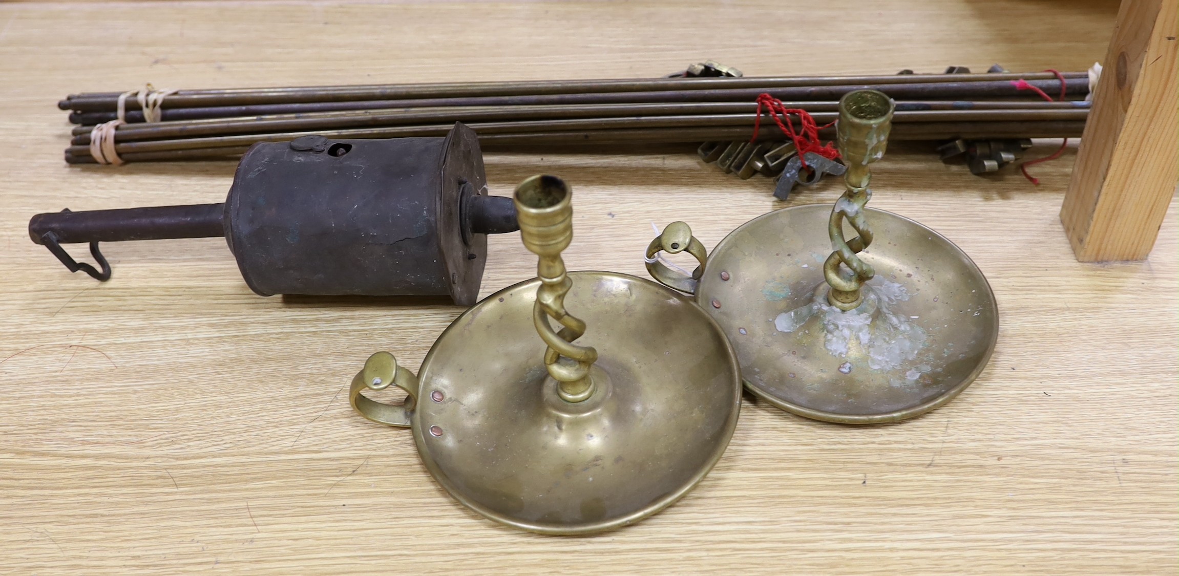 A group of mixed metalware, to include a pair of chamber sticks, a meat timer, and stair rods